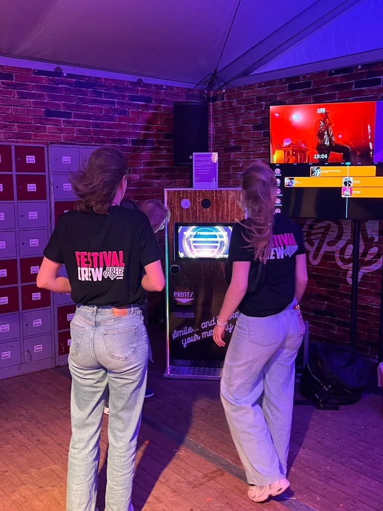 Photobooth Kiosk in gebruik op een festival met paarse sfeerverlichting