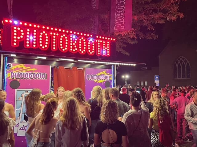 Gloeiende PHOTOBOOTH XXL met publiek op een zomeravond