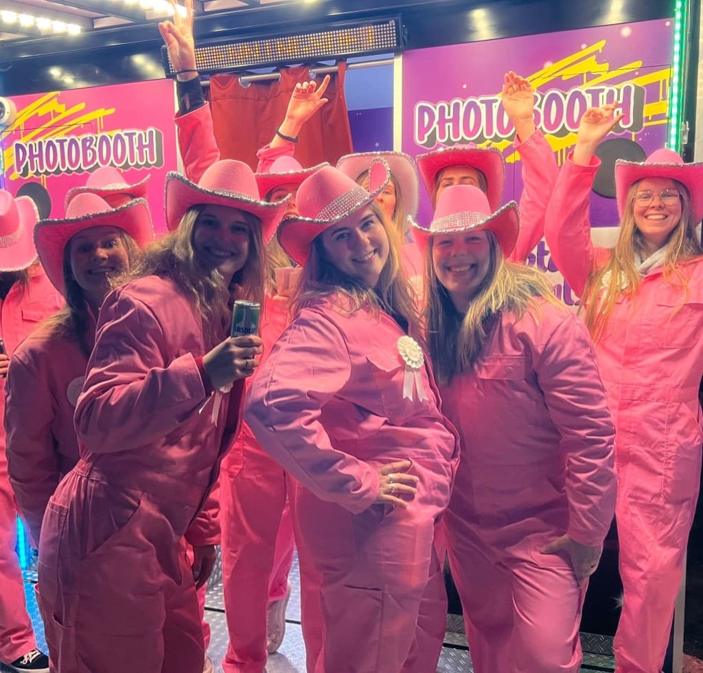 Groep in feestelijke outfits poseert voor de photobooth